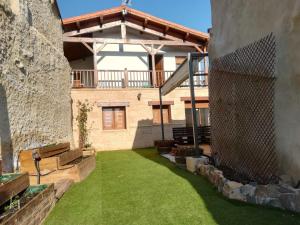 a patio with a yard with green grass at Casa Ecoeficiente Eguzkilore in Torrelles