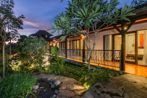 a house with a garden in front of it at Villa Beji Mawang Ubud by GenuineHost in Ubud