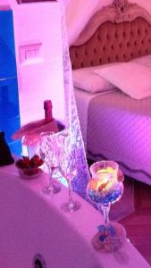 two wine glasses sitting on a table next to a bed at B&B Piccolo Paradiso in Finale Ligure