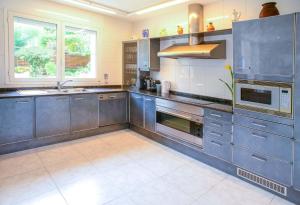 a large kitchen with stainless steel appliances and blue cabinets at Villa Melody in San Antonio Bay
