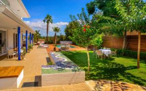 a backyard with a garden with a table and chairs at Villa Melody in San Antonio Bay