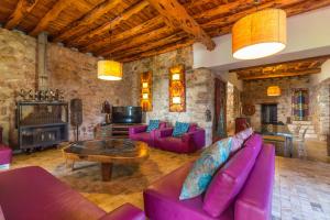 a living room with purple furniture and a fireplace at Villa Sarahmuk in Santa Agnès de Corona