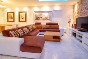 a living room with a couch and a tv at Villa Melody in San Antonio Bay