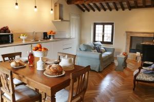 a kitchen and living room with a wooden table with food on it at Rambaldi Apartments Casa nr 1 in Bardolino