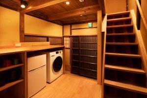 a laundry room with a washer and dryer at Kanade Matsubaragokomachi-Momijittei in Kyoto