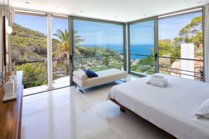 a bedroom with a view of the ocean at Villa Vadella by Eivillas in Cala Vadella