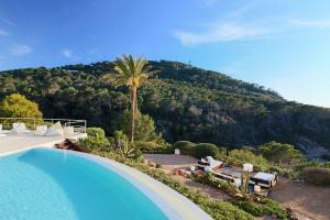 a swimming pool with a view of a mountain at VILLA VADELLA in Cala Vadella