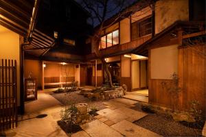 a building with a courtyard in front of it at night at Kanade Matsubaragokomachi-Momijittei in Kyoto