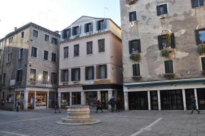 een groep gebouwen met mensen die in een straat lopen bij THE LOVERS in Venetië