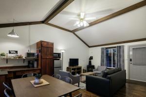 ein Wohnzimmer mit einem Deckenventilator und einem Tisch in der Unterkunft Bramblebank Cottages in Harrison Hot Springs