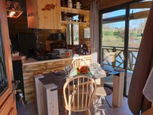 - une cuisine avec une table et des chaises dans une cabine dans l'établissement Etangs du Moulin, à Suzy