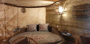 1 dormitorio con 1 cama en una habitación con paredes de madera en Etangs du Moulin, en Suzy