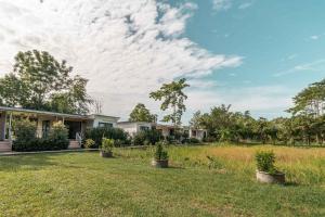 une maison avec des plantes en pot dans une cour dans l'établissement Summer Resort in Nakhon Nayok, à Nakhon Nayok