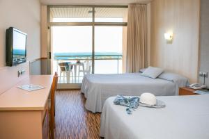 um quarto de hotel com duas camas e uma grande janela em RVHotels Hotel Ametlla Mar em L'Ametlla de Mar