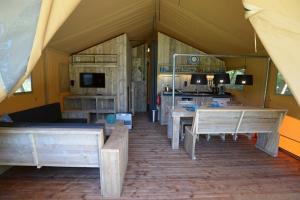 a living room with wooden tables and a kitchen at Camping Campo dei Fiori - Glamping4all in Vada