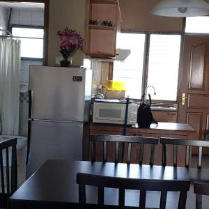 a kitchen with a refrigerator and a table with chairs at Seri Bulan Condo in Port Dickson