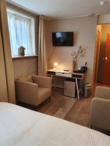 a hotel room with a desk and a tv on the wall at City Hotel Meppel in Meppel