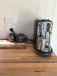 a black coffee maker sitting on a wooden counter at Tiny House in Woonona