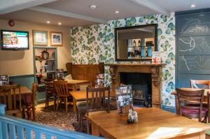 a restaurant with tables and chairs and a fireplace at Lamb & Flag Inn in Abergavenny