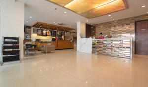 丹格朗的住宿－d'primahotel Airport Jakarta 1，一间商店大厅,里面设有药店和一名女士