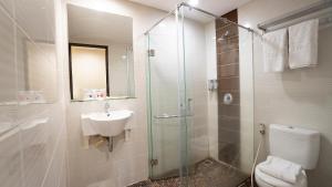un bagno con doccia, lavandino e WC di d'primahotel Airport Jakarta 1 a Tangerang