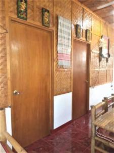 a room with a wooden door and a table at Felipa Beach and Guesthouse - Lotus in Dumaguete