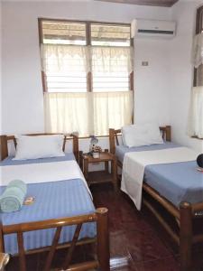 een kamer met 2 bedden en een raam bij Felipa Beach and Guesthouse - Lotus in Dumaguete