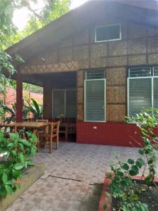 un patio di una casa con tavolo e sedie di Felipa Beach and Guesthouse - Lotus a Dumaguete