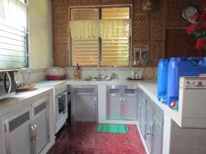 a kitchen with white cabinets and a sink and a window at Felipa Beach and Guesthouse - Lotus in Dumaguete