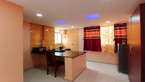 a kitchen with a table and a refrigerator at FAMILY FRIENDLY STUDIO APARTMENT in Bengaluru