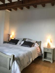 a bedroom with a bed and a table with a lamp at Chambre d hôtes Domaine Des Patrus in LʼÉpine-aux-Bois