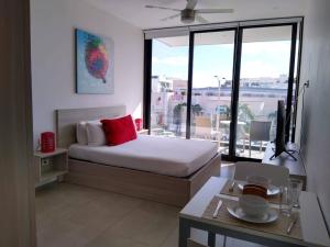 ein Schlafzimmer mit einem Bett und einem großen Fenster in der Unterkunft Studio close to 5th Av, with Amazing Roof Pool View, Gym, Spa and more in Playa del Carmen + 37 Fotos