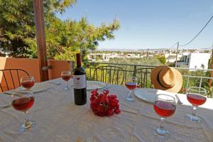 una mesa con copas de vino y una botella de vino en Glaros Home en Kato Daratso