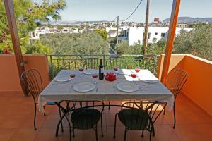 una mesa con sillas y una botella de vino en el balcón en Glaros Home en Kato Daratso