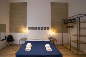 una camera da letto con un letto e due asciugamani di Borgo Vergini Garden B&B a Napoli