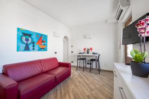 a living room with a red couch and a table at Borgo Aureo in Rome