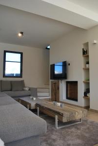 a living room with a couch and a tv at Villa Marièle in Malaucène