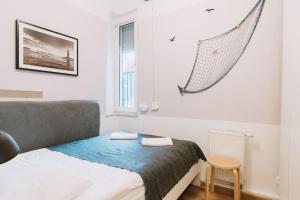 1 dormitorio con 1 cama y 1 hamaca colgada en la pared en Sopot Host Molo, en Sopot