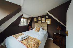 a bedroom with a bed with white sheets and a window at Central Bath Townhouse ‘Founders House’ in Bath