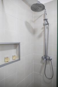 a shower with a shower head in a bathroom at Toi et Moi Apartments-Guests speek for us! in Ponta Delgada