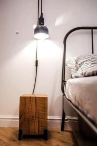a bedroom with a bed with a lamp and a wooden stool at IRANYI Home - flat in the heart of downtown in Budapest