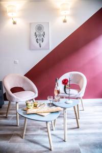 een kamer met twee stoelen en een tafel met een roos erop bij LE PETIT AVIGNONNAIS - APHRODITE - INTRAMUROS - CENTER - in Avignon