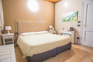 1 dormitorio con 1 cama y 2 mesitas de noche blancas en Torre Soave - Locazione Turistica, en Soave