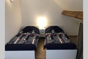 2 camas en una pequeña habitación contigua en Duplex agréable et spacieux 3 chb dont 1 communicante en Vendeville