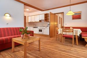 uma sala de estar com um sofá vermelho e uma mesa em Sonnberg Ferienanlage em Flachau