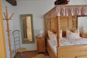 een slaapkamer met een hemelbed met een ladder en een spiegel bij Ferienwohnung Gäste Oase in Bad Windsheim