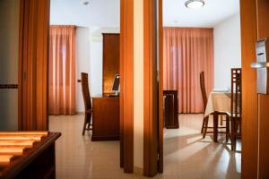 a living room with a table and a dining room at Hotel Califfo in Quartu SantʼElena