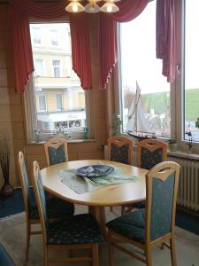 a table and chairs in a room with a window at Villa Hebel in Cuxhaven