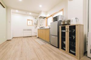 a kitchen with stainless steel appliances and wooden floors at TKD HOUSE Asahikawa in Asahikawa