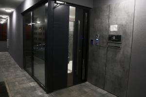 a hallway with two glass elevators in a building at Apartman Natasa sa podzemnom garažom in Banja Luka